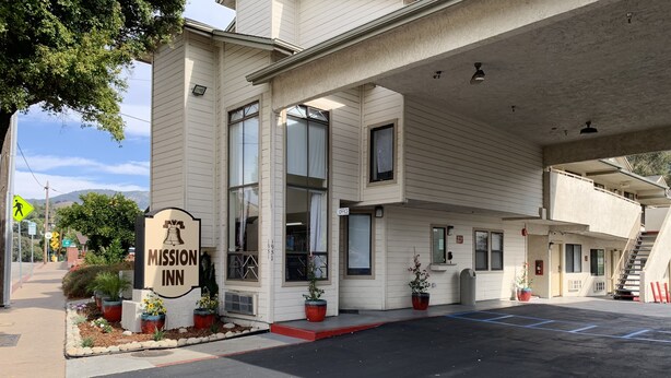 A two-story motel with a sign reading "Mission Inn" and a parking lot with directional arrows. - Mission Inn San Luis Obispo (San Luis Obispo)