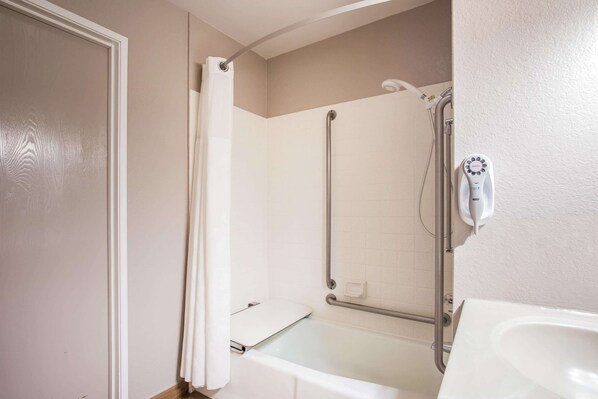 A bathroom with a shower, a toilet, and a sink.