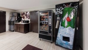 A compact kitchen with a refrigerator, microwave, and a 7UP vending machine. - Red Roof Inn Mansfield (Mansfield)