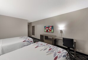 A hotel room with two beds, a desk, a chair, a TV, and a wall-mounted light. - Red Roof Inn Mansfield (Mansfield)
