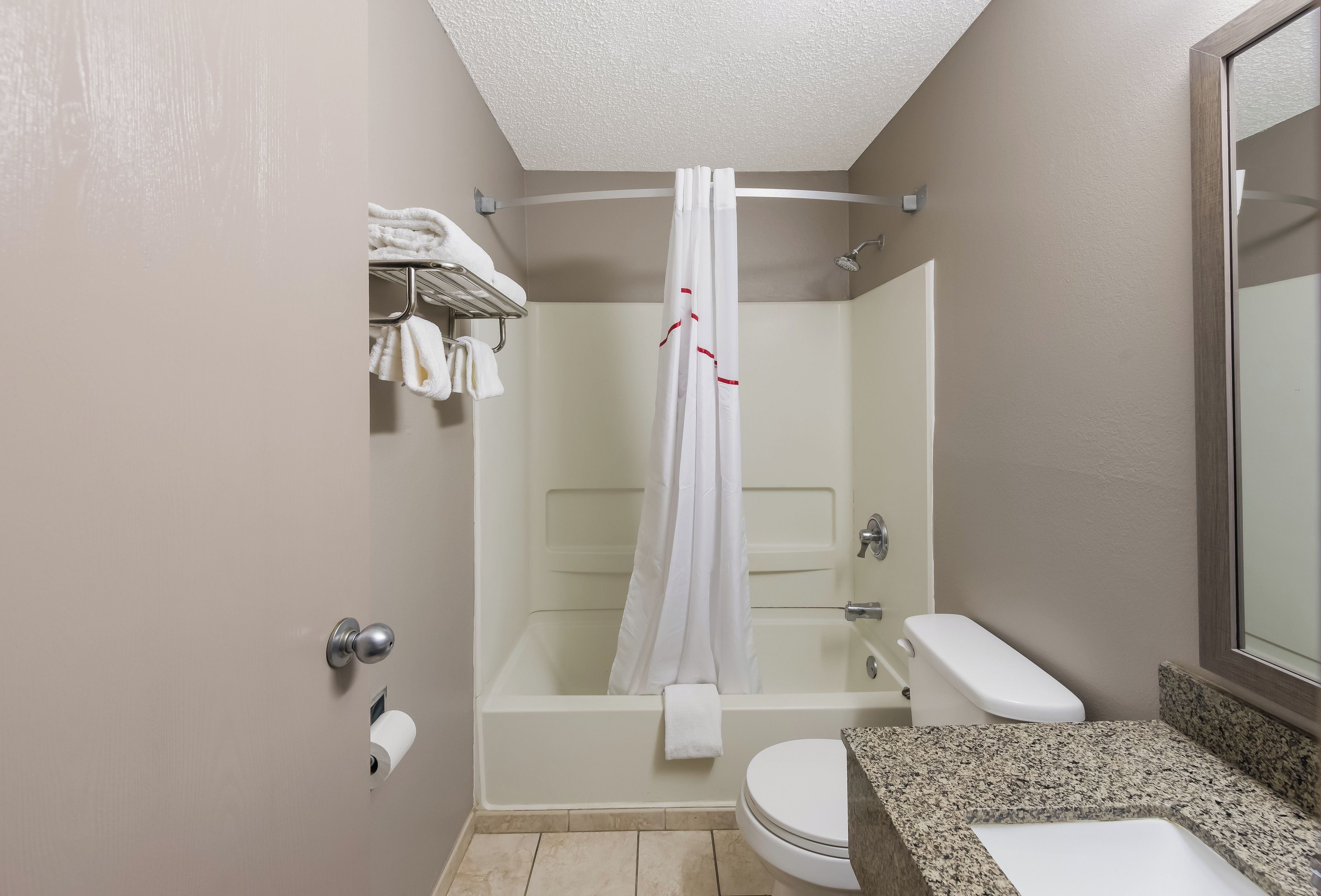 A bathroom with a shower, toilet, and sink.