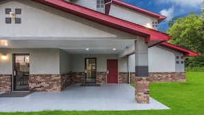 A modern two-story house with a covered front porch, brick accents, and a red roof. - Red Roof Inn Mansfield (Mansfield)
