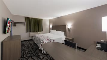 A hotel room with a bed, bedside tables, a desk, a chair, a television, and a window with curtains.