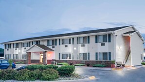 A motel with a flat roof, multiple windows, and a front entrance with a small porch.