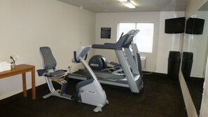 A fitness center with treadmills, a stationary bike, and a wall-mounted TV. - Travelodge by Wyndham Jefferson City (Jefferson City)