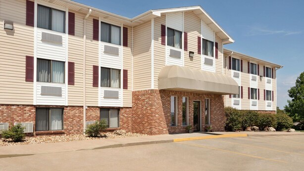 A multi-story hotel with a brick facade, large windows, and a covered entrance.
