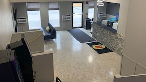 A modern hotel lobby with a reception desk, seating area, and large windows. - Super 8 by Wyndham Kirksville-University Area (Kirksville)