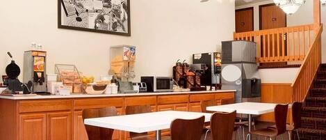 A modern kitchen with a central island, wooden cabinets, and a dining area with chairs.