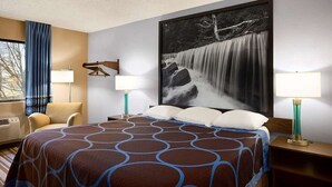 A hotel room with a large bed, two bedside tables, a chair, a window with curtains, and a large wall-mounted picture of a waterfall. - Americas Best Value Inn Pittsburg (Pittsburg)