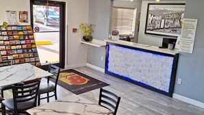 L’intérieur d’un restaurant, avec un comptoir d’accueil, un détecteur d’incendie, un tableau de menu fixé au mur et un présentoir de collations.