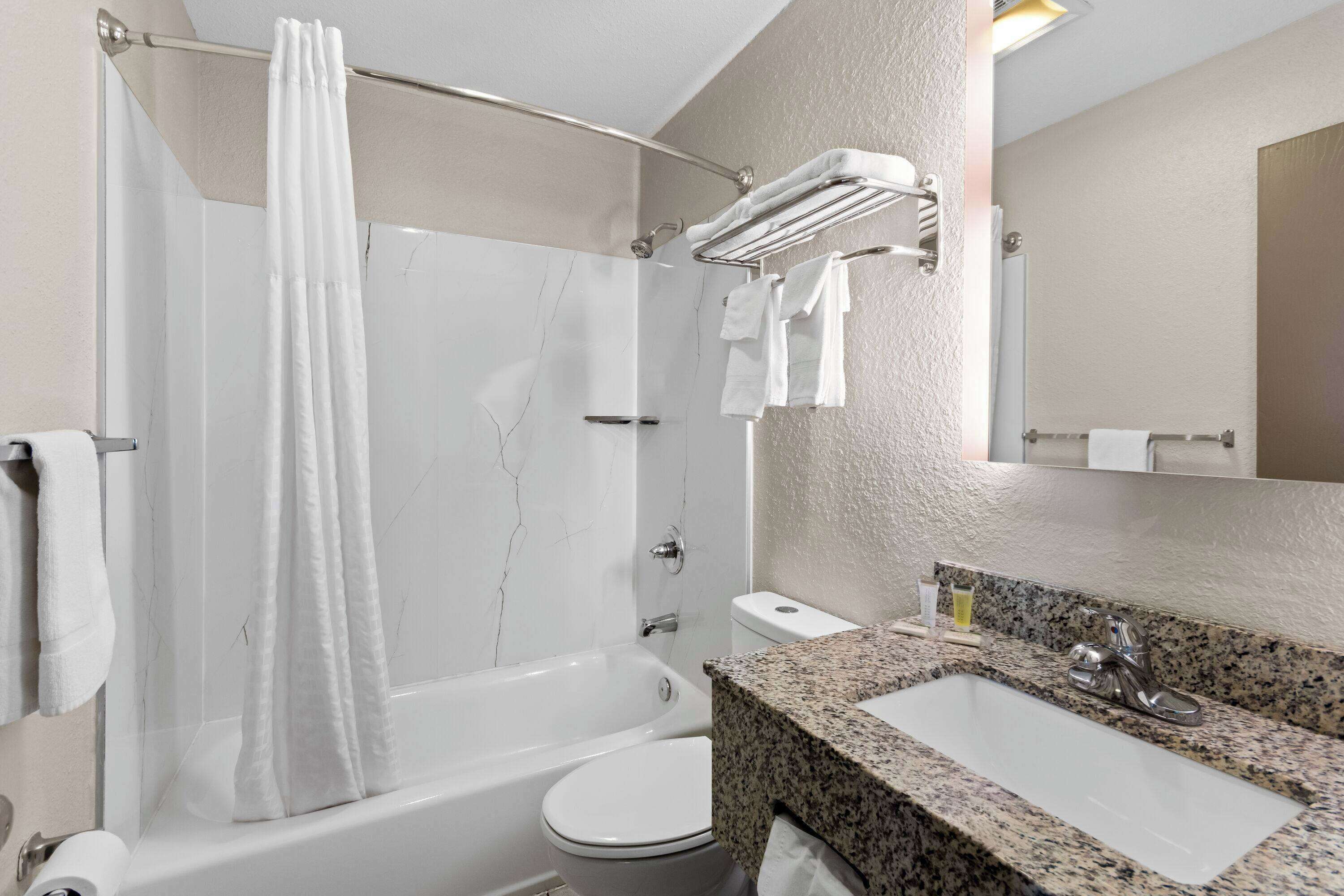 A modern bathroom with a bathtub, toilet, and sink.