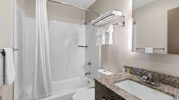 A modern bathroom with a bathtub, toilet, and sink.