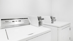 Une laveuse commerciale blanche, robuste et de qualité supérieure, dotée d’un panneau de commande affichant différents réglages.