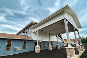 A building with a covered entrance, a number '13901' on the wall, and a 'Welcome' sign.