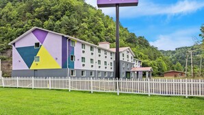 A hotel with a colorful exterior, a white picket fence, and a sign that reads 'spark by Hilton'.
