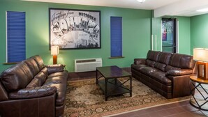A living room with two leather sofas, a coffee table, and a framed picture on the wall.