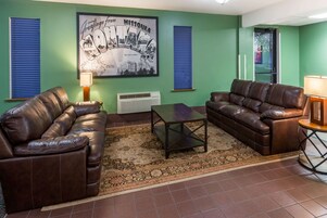 A living room with two leather sofas, a coffee table, and a framed picture on the wall.