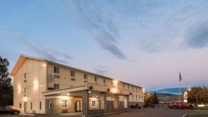 A multi-story hotel with a covered entrance and a parking lot.