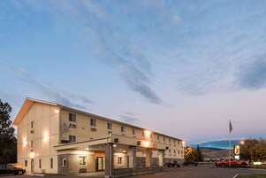 A multi-story hotel with a covered entrance and a parking lot.