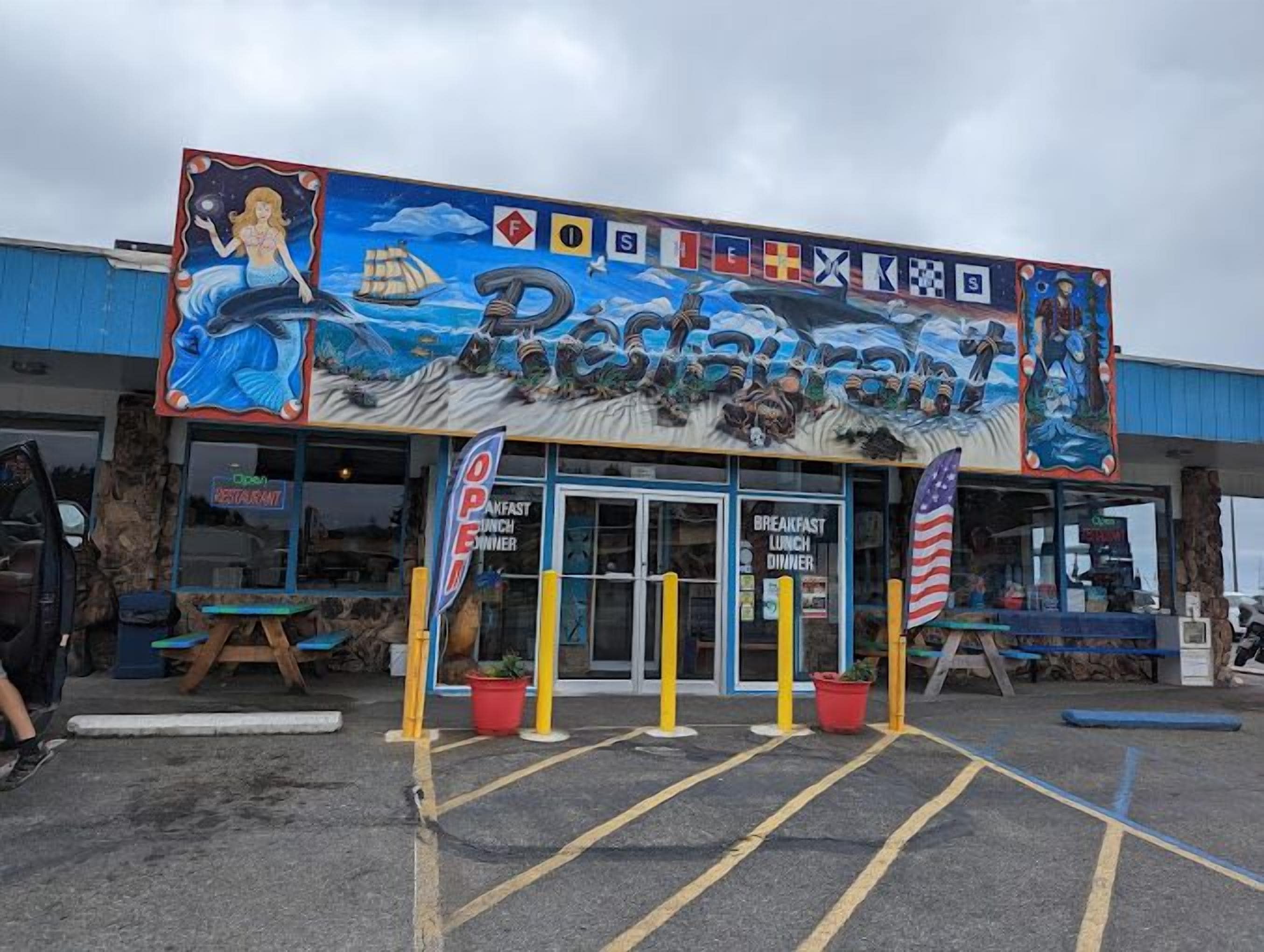 A restaurant with a nautical theme, including a mermaid mural and flags.
