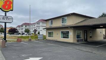 Un motel Super 8 con un estacionamiento, un edificio de fachada color beige y un cielo despejado.