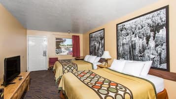 Habitación de hotel con dos camas, un televisor, un escritorio y obras de arte en las paredes.