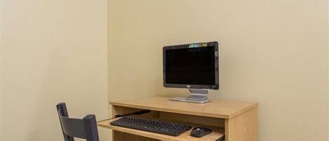 Un escritorio pequeño y sencillo con un monitor de computadora, teclado y ratón.