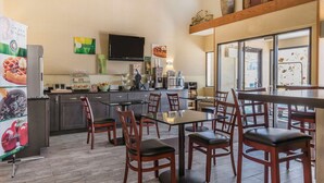 Cocina moderna con comedor, equipada con refrigerador, microondas y cafetera.