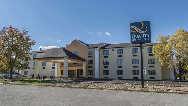 A hotel with a sign reading "Quality Inn & Suites" and a covered entrance.