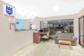 A reception area with a desk, computer, and a sign indicating non-smoking rooms. - Hotel Express (Anniston)