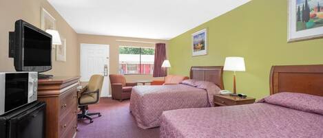 Une chambre d’hôtel avec deux lits, un bureau avec une télévision, une chaise et une fenêtre avec des rideaux.