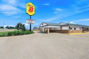 Un motel Super 8 con cielo despejado, un letrero de bienvenida para camioneros y una estructura de edificio sencilla.