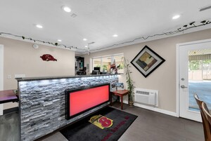 A reception area with a stone counter, a red clock, and a framed picture on the wall.