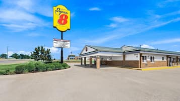 A Super 8 motel with a clear sky, a welcoming sign for truckers, and a simple building structure.