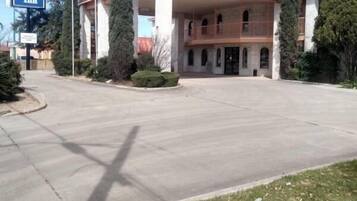 A Budget Inn with a central courtyard, a parking lot, and a clear sky.