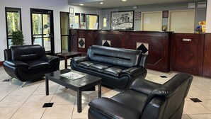 A lobby with leather seating, a reception desk, and a chandelier.