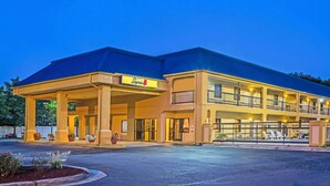 A Super 8 hotel with a two-story structure, covered parking, and outdoor seating area.