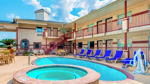 Un hôtel doté d’une piscine, de plusieurs balcons et de chaises longues.