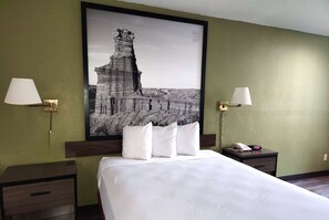 A hotel room with a large bed, two bedside tables, a nightstand, and a framed picture on the wall. - Super 8 by Wyndham Austin North/University Area (Austin)
