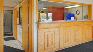 A reception area with a wooden counter, a clock on the wall, and a number 825 sign. - FairBridge Inn Express Merrillville (Merrillville)