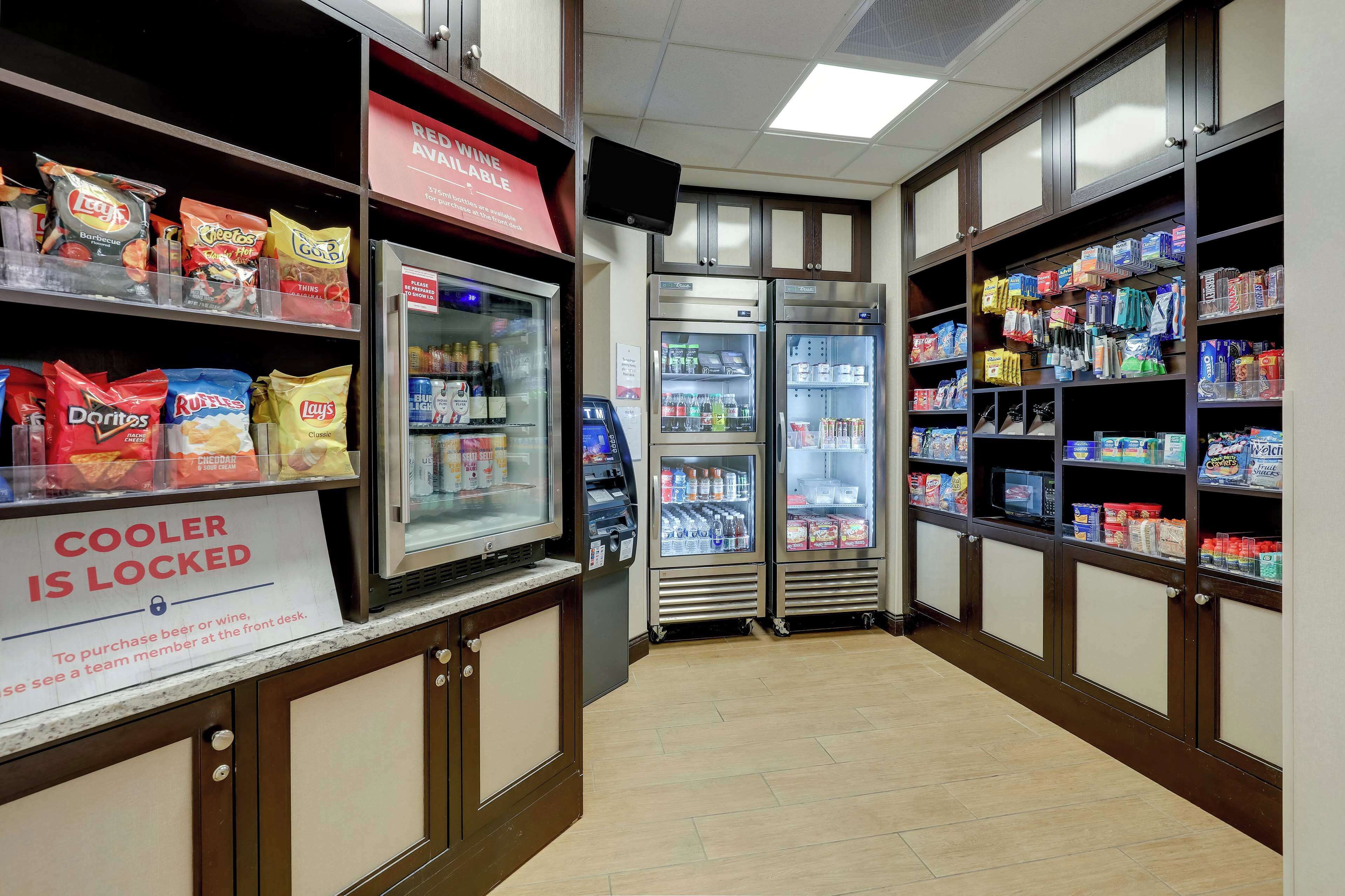 A store with snack aisles, refrigerated sections, and a sign indicating the cooler is locked.