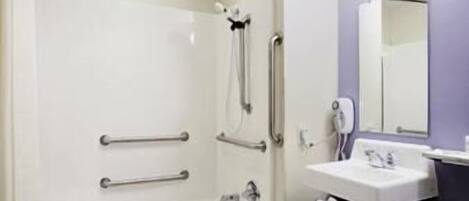 A bathroom with a bathtub, a sink, a mirror, and a towel rack.