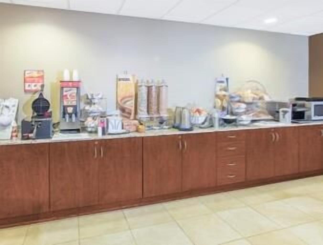 Un coin cuisine comprenant un plan de travail, des placards et divers appareils, notamment une machine à café, un four à micro-ondes et un grille-pain.
