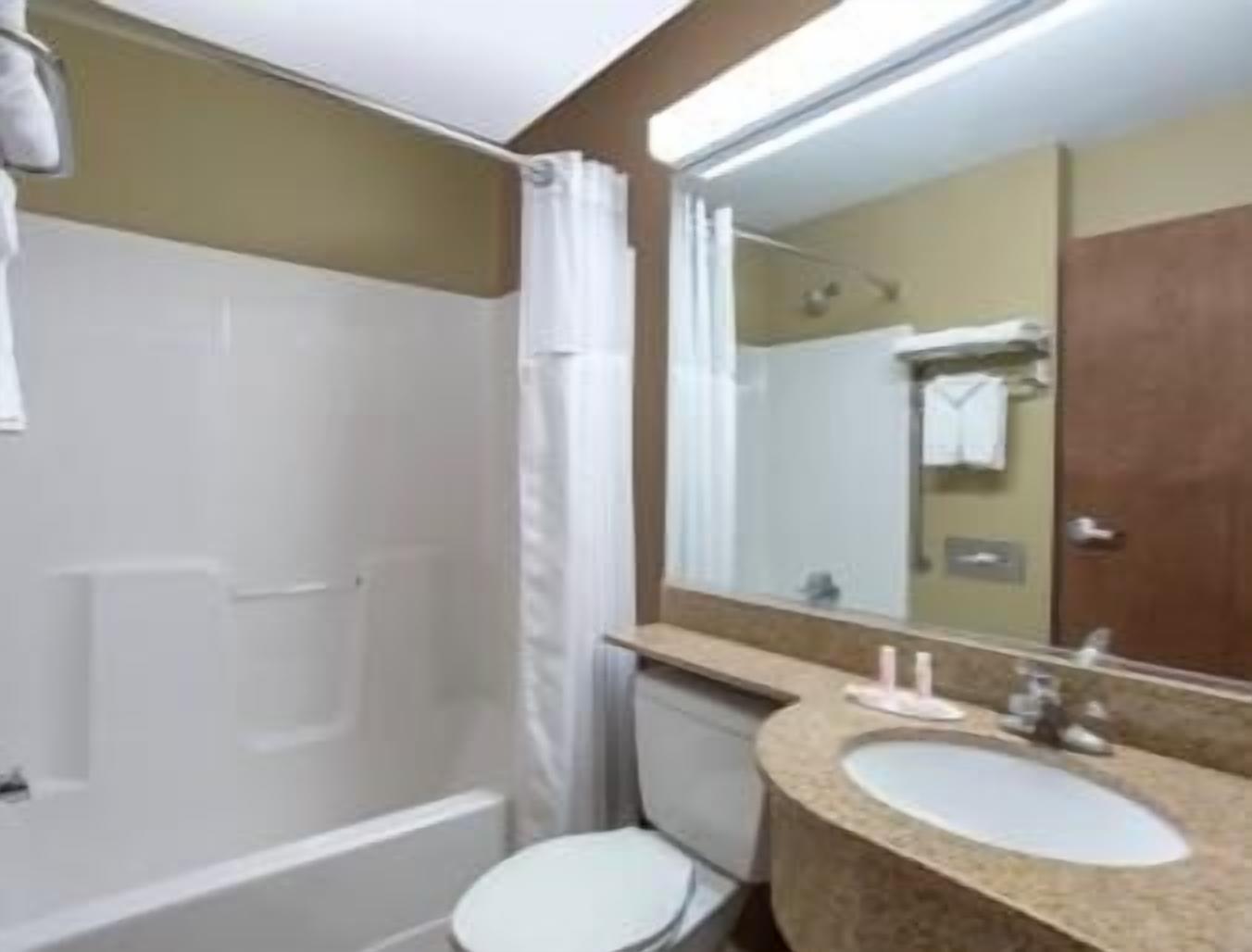 Un baño con bañera, lavabo y espejo.