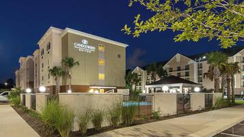 A hotel building with a sign reading 'Candlewood Suites' at night.