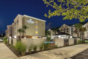 Un edificio de hotel con un letrero que dice 'Candlewood Suites' de noche.