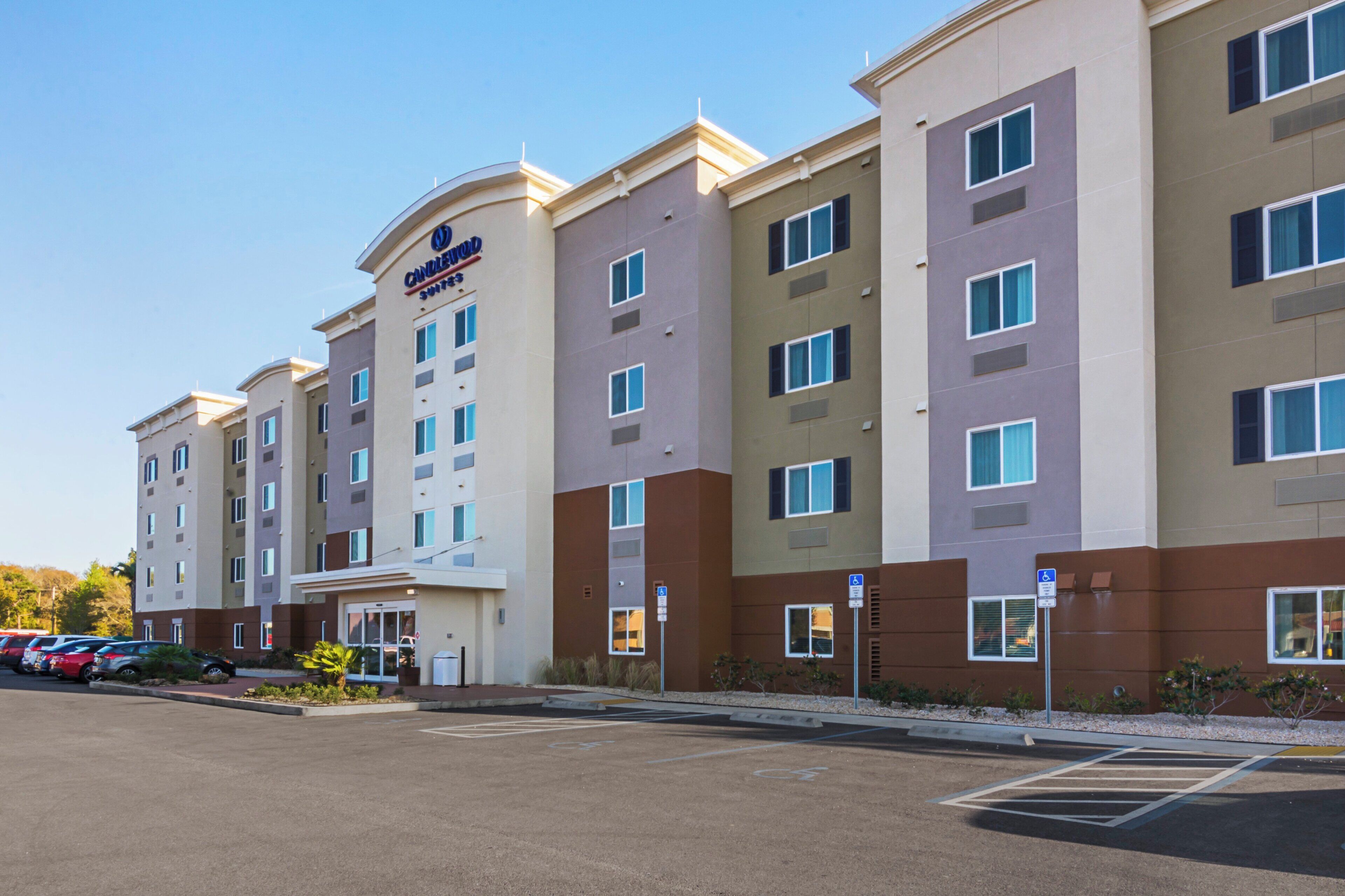 A multi-story hotel with a modern design, featuring a prominent 'Candlewood Suites' sign.