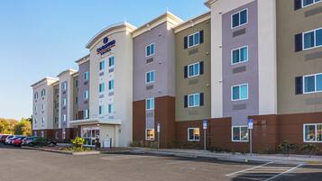 A multi-story hotel with a modern design, featuring a prominent 'Candlewood Suites' sign.