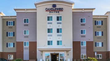 A multi-story hotel with a central entrance, multiple windows on each floor, and a sign indicating it is a Candlewood Suites.