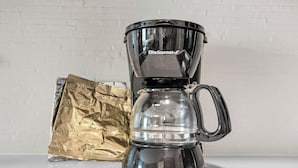 A coffee maker with a clear glass carafe and a handle, placed on a countertop. - Candlewood Suites Pensacola - University Area by IHG (Pensacola)